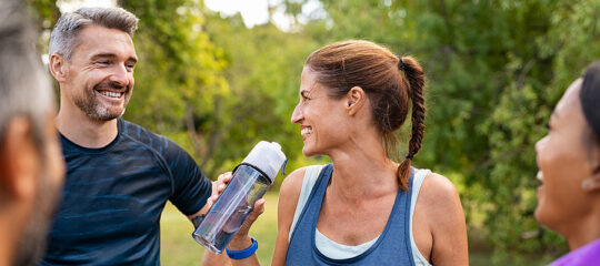 Man and Woman exercising outdoors and laughing together.